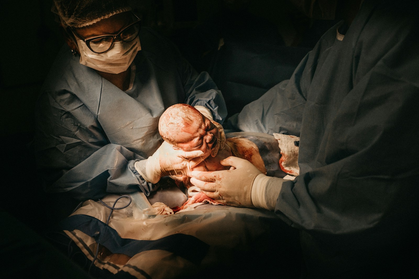two person holding newborn baby